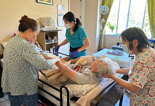3 people assisting an elderly person