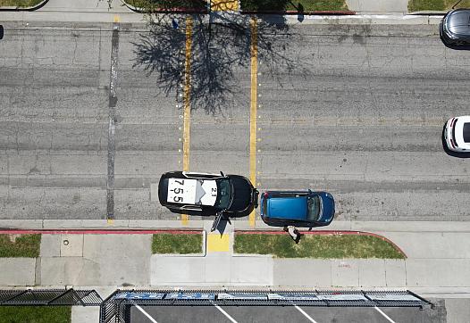 An aerial view of a deputy sheriff pulling over a driver in front of a school