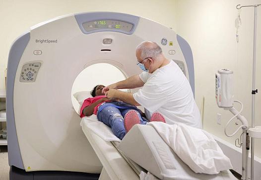 Person attending to someone laying in an MRI machine