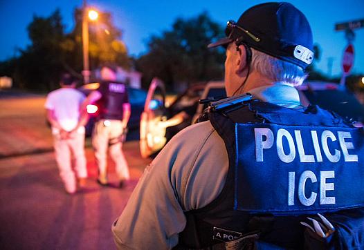 A police wearing ICE jacket 