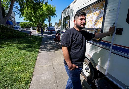 A person standing rear an RV