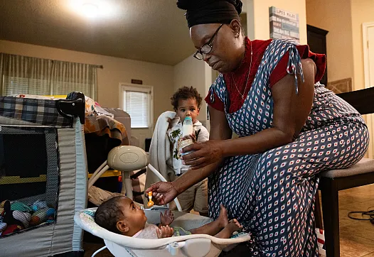 A person feeding a baby with a spoon