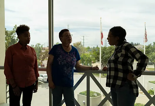 Three people standing over a balcony
