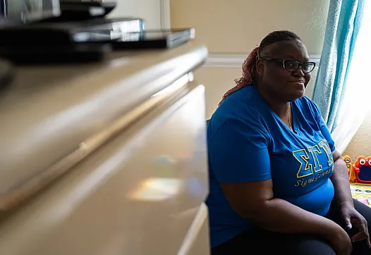Person in blue top sitting in a room