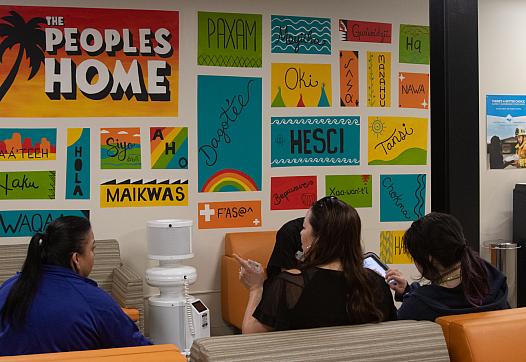Three women wait in the colorful waiting room of UAII in Echo Park, Los Angeles