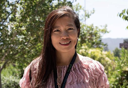 Person in pink top standing outdoors
