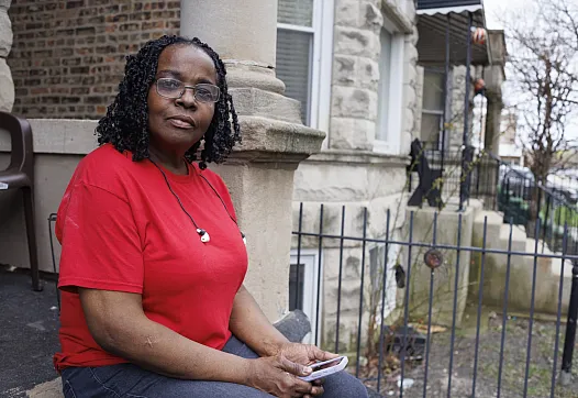 A women sitting by a house 