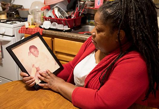 Cherry DeJesus looks at a photo of herself as a 4-year-old girl in her New Jersey home on Feb. 26, 2023. She’s a survivor of child sexual abuse and experienced hypersexualization as a child. (Chantel Philip/Word In Black)