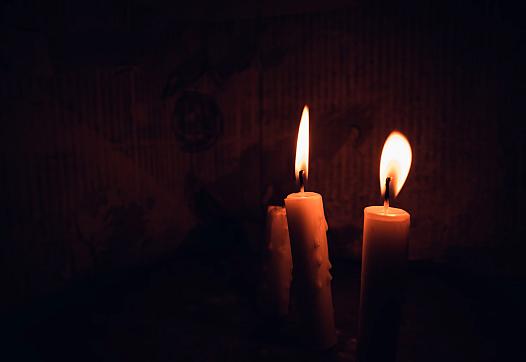 Two Candles Lit Inside a Dark Room