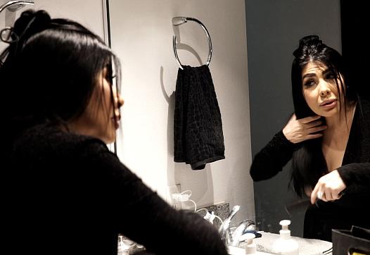 Person doing makeup in front of a mirror