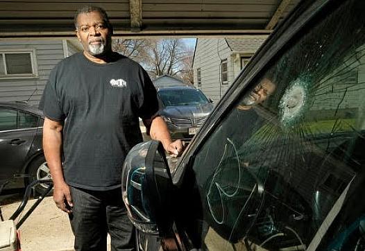 Pastor Kevin Simmons, who was shot during a carjacking, stands next to the Jeep he was in when he was shot