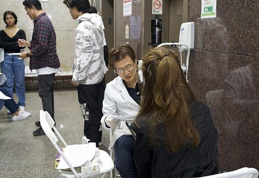 Person sitting in front of someone in a white coat