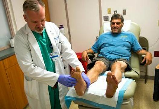 Dr. Eric Espensen checks the legs and feet of Paul Vinci at the Amputation Prevention Center.