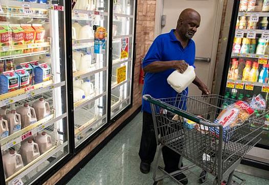 A customer buys a gallon of milk in the Cash Saver grocery store on Wilson Avenue. Sept. 25, 2018