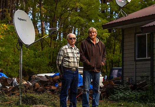 Outside their home in Keller, Ferry County, Marshel Sumerlin, left, and his son, Lee, have satellite dishes that Sumerlin has u