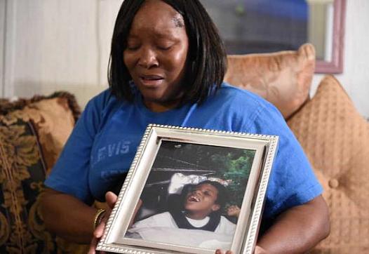Jessie Evans becomes emotional as she holds a portrait of her son, Cornelius James Evans, taken when he was 5 years old, at her home in Donalsonville, Ga. JON-MICHAEL SULLIVAN/STAFF
