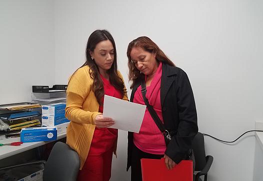 Medical assistant Deisy Hernandez discusses an upcoming appointment with patient Caya Mendoza, 62, inside Clinica Romero in Boy