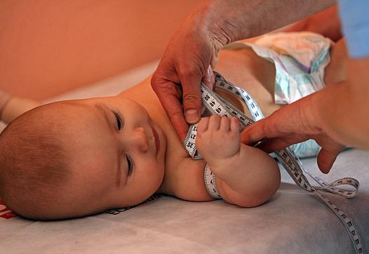 An infant gets measured as part of a health check