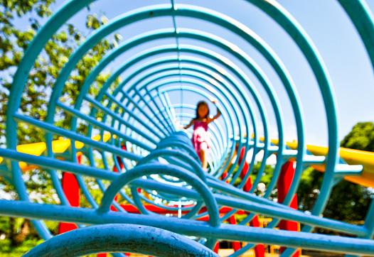 This is a photo of a child in a playground jungle gym.