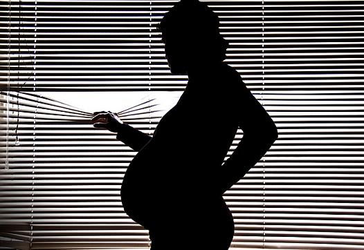 pregnant woman looking out of window