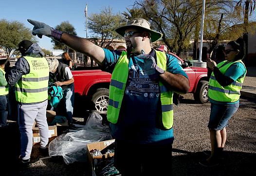 Lorenzo Gonzalez, head of the Healthy South Tucson Coalition, directs a trash cleanup on South Sixth Avenue, an area of concentr