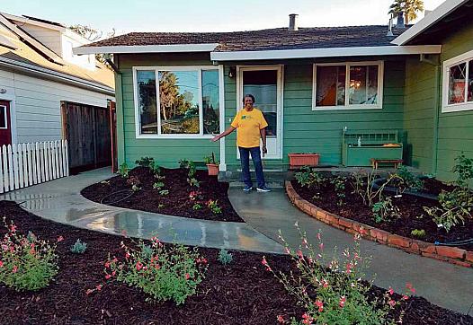 Carrie Whitley shows off a new garden in front of her Santa Cruz home. Habitat for Humanity Monterey Bay helped add a 500-unit A