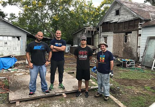 Amilcar Heredia, Eduardo Assef, Robert Santos and Isaac Fonseca stand outside Reynaldo Garza’s home after cleaning up debris in
