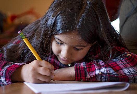 Fernanda Davila works on a spelling packet at the kitchen table in her Phoenix home on March 8, 2022.