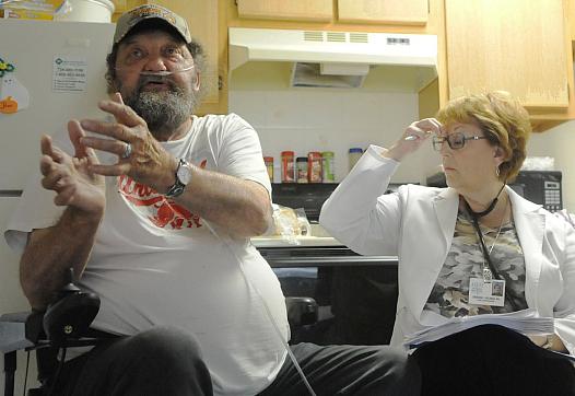 Clifford Schmidt, 71, talks with Monongahela Valley Hospital nurse Deborah Holman during a scheduled home visit in Mon Valley.