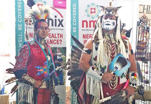 Two dancers in regalia work a Native American Professional Parent Resources outreach booth at the 2014 Gathering of Nations powwow in Albuquerque, N.M. | Courtesy Photo