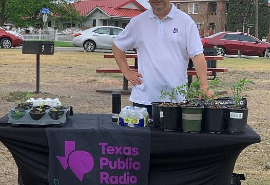 David Martin Davies stands at a table in a park near the West Side of San Antonio as part of an effort to meet people where they