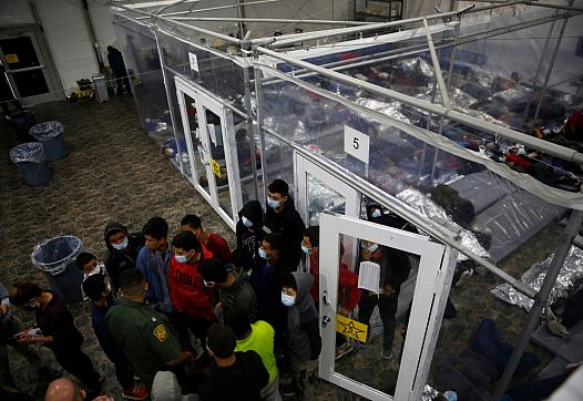 Minors talk to an agent outside a pod at the Department of Homeland Security holding facility run by the Customs and Border Patr