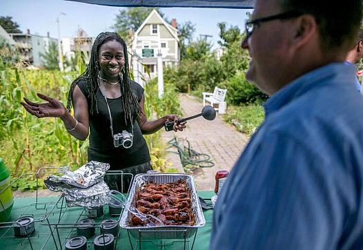 Jhana Senxian, left, founder of the Coleman Street Neighbors Association, served food in the community garden during a block party in September. ARAM BOGHOSIAN FOR THE BOSTON GLOBE