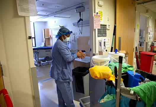 A member of housecleaning services disinfects her hands after cleaning a room in a COVID-19 unit at a Seattle hospital last year
