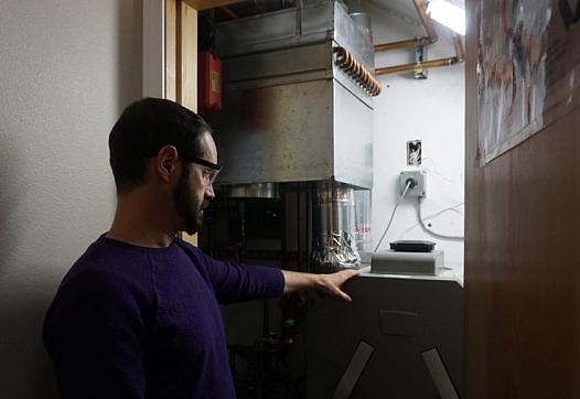 Aaron Cooke demonstrates a heat-recovery ventilator at his house in the sustainable house at the Cold Climate Housing Research C