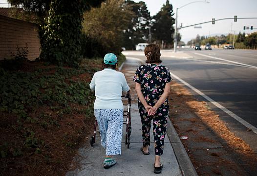 Ana Nicho Luu, 66, right, takes her mother, Maura Nicho, 90, who has Alzheimer’s disease, for a short walk around their Santa Cl