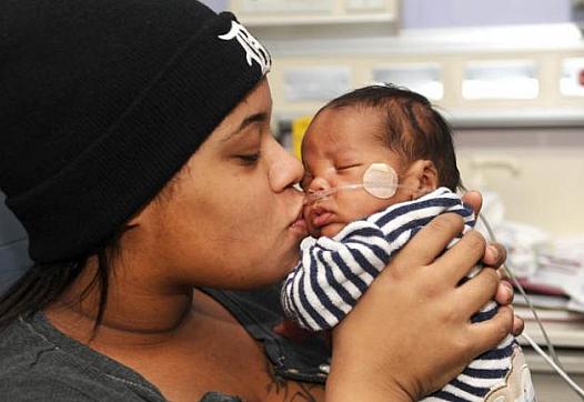 Alaina Gonville kisses her 3-month-old Brandon at the Neonatal Intensive Care Unit at Hutzel Women's Hospital in Detroit. Brandon was born premature through an emergency C-section. (Max Ortiz / The Detroit News) 