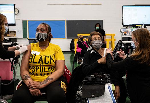 Andrea Moore and her mother Alma Penn receive COVID-19 vaccines in an elementary school gym on April 2 in Louisville, Kentucky. 