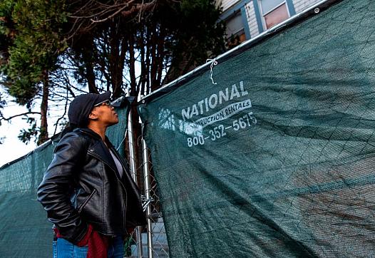 Moms 4 Housing activist Misty Cross surveys the fenced-off vacant Oakland home that she and other homeless mothers occupied duri