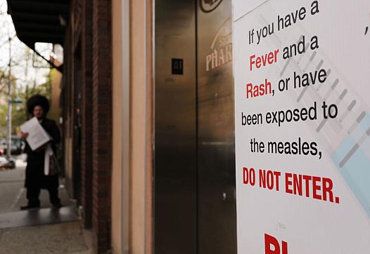 A sign warns people of measles in the ultra-Orthodox Jewish community in Williamsburg in New York City. (Photo by Spencer Platt/