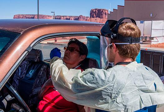 A nurse takes a swab sample from a Navajo Indian woman complaining of virus symptoms at a COVID-19 testing center at the Navajo 