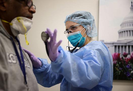 A nurse practitioner examines a patient.