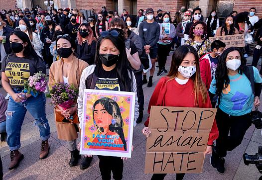 Demonstrators wearing face masks and holding signs take part in a rally to raise awareness of anti-Asian violence 