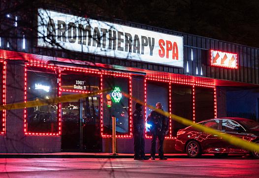 Law enforcement personnel are seen outside a massage parlor where a person was shot and killed on March 16, 2021, in Atlanta, GA