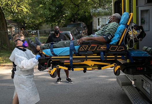 Medics transport a man with COVID-19 symptoms to the hospital in August 2020 in Austin, Texas.
