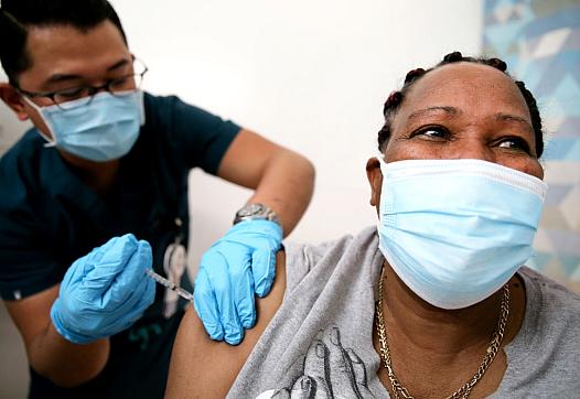  Lorraine Harvey, an in-home care worker, receives her first dose of the COVID-19 vaccine