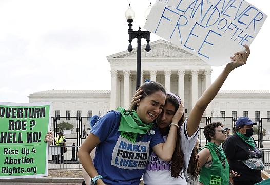  Abortion rights activists Carrie McDonald (L) and Soraya Bata react to the Dobbs v Jackson Women’s Health Organization ruling w