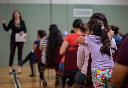 A girl watches during a workshop that teaches immigrants how to make a preparedness plan. (Photo: David McNew/AFP/Getty Images)