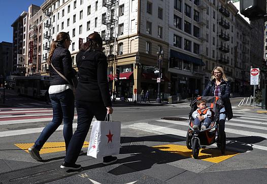 San Francisco residents wait in line for a food basket giveaway. (Photo by Justin Sullivan/Getty Images)