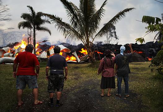 Community members watch as a home is destroyed by lava from a Kilauea volcano fissure in Leilani Estates, on Hawaii's Big Island